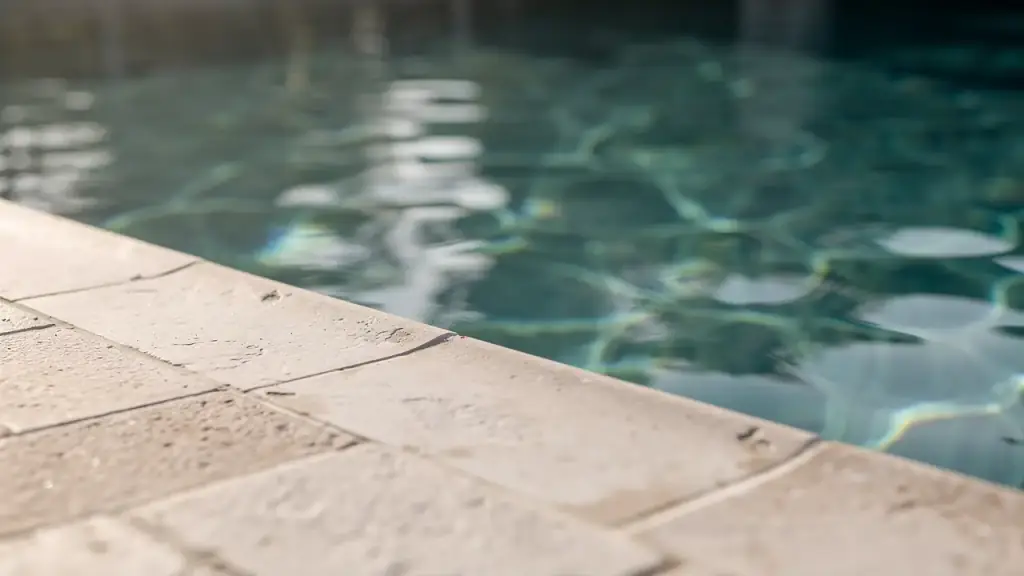Close view of pool water beside a travertine coping